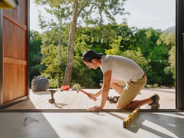 man repairing deck with tools