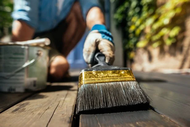 person staining deck