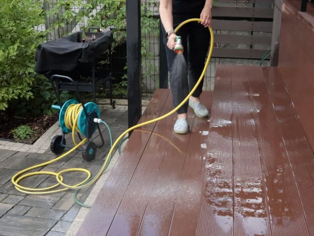 woman power washing deck