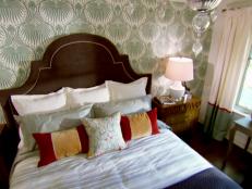 Candice adds focus to a bold patterned wall with an upholstered headboard.